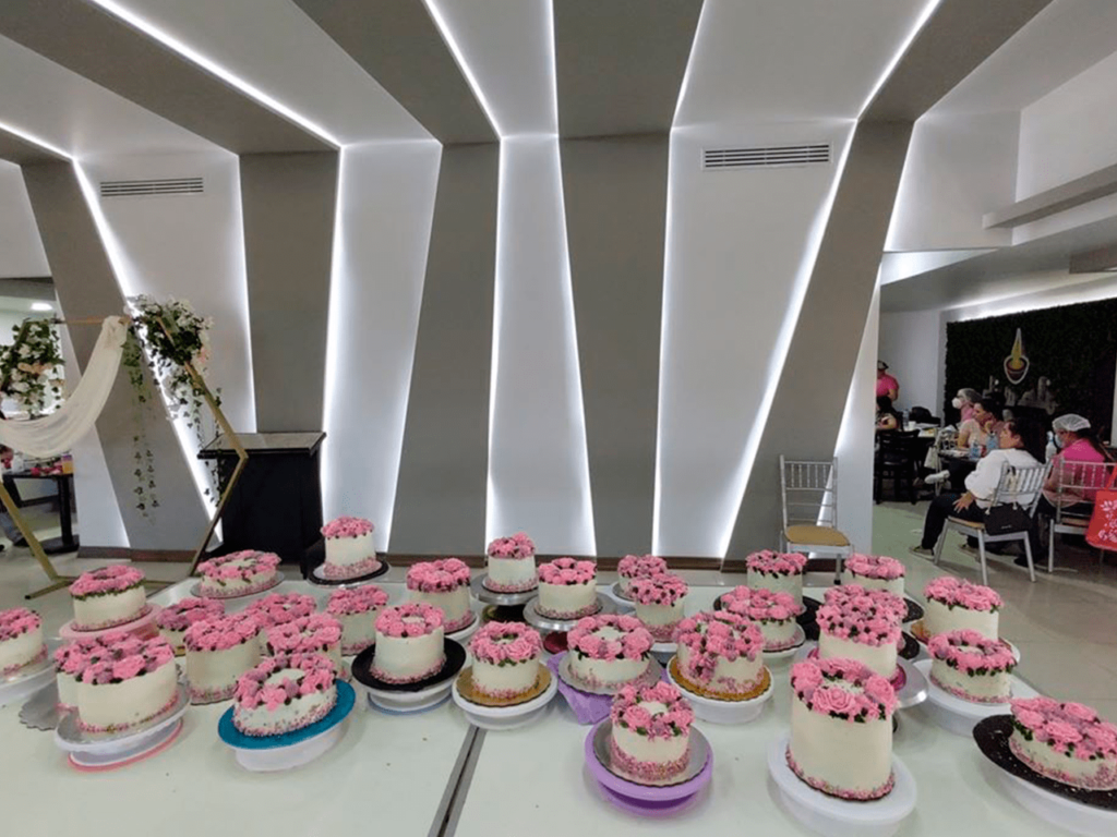 Mesa llena de pasteles de un curso de repostería GLAM.