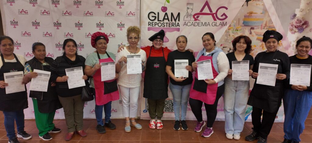 Grupo de mujeres graduadas de la Academia Glam Repostería mostrando sus diplomas con orgullo.