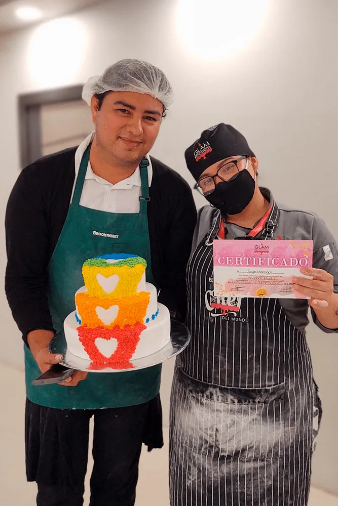 Entrega de diplomas y reconocimiento a estudiante por completar el curso de repostería técnica con su pastel de tres niveles.